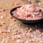 A small wooden bowl filled with Himalayan Crystal salt. This salt supports healthy respiratory function and vascular health.