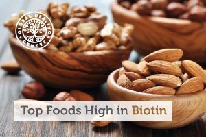 A table with organic mixed nuts. Biotin is an essential vitamin that is commonly found in foods such as nuts and vegetables.