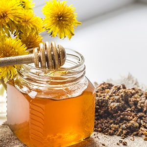A glass bottle of honey. Bee propolis can help support the immune system.