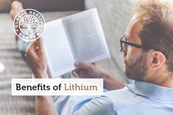 A man focusing on reading a book. Increased focus is a benefit of lithium.