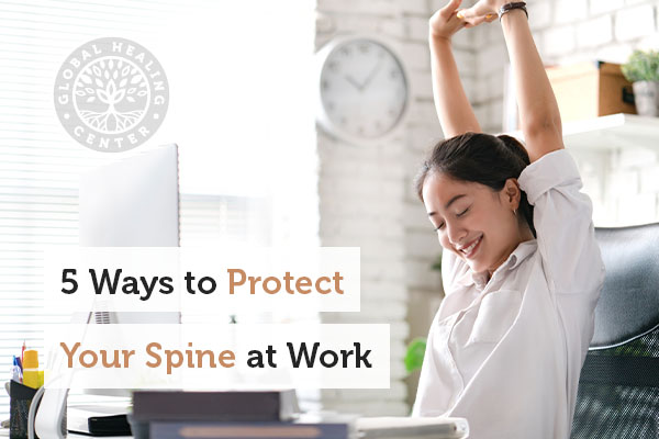 A woman stretching to protect her spine at work.